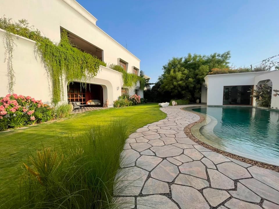 A stone path curving across a lawn towards the pool
